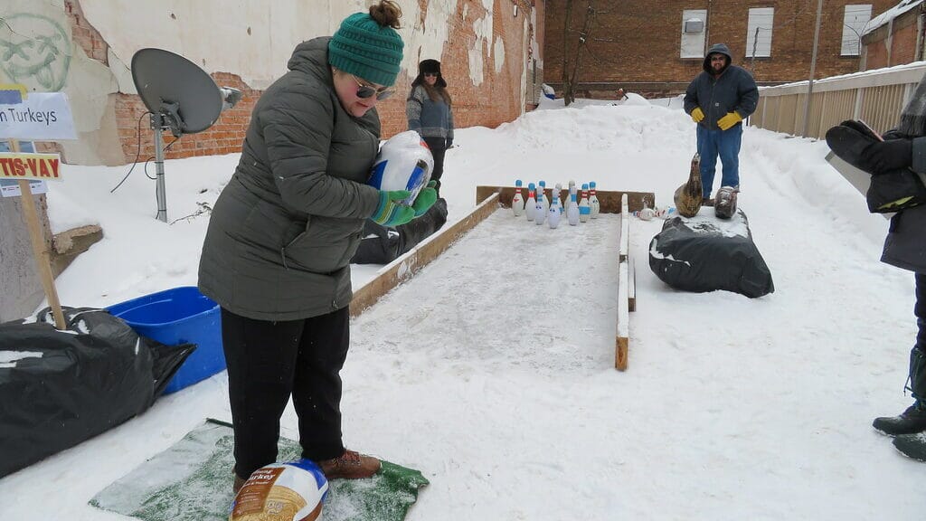 Competitors rolling frozen turkeys down a lane in a turkey bowling competition, one of the strangest sports in the USA.