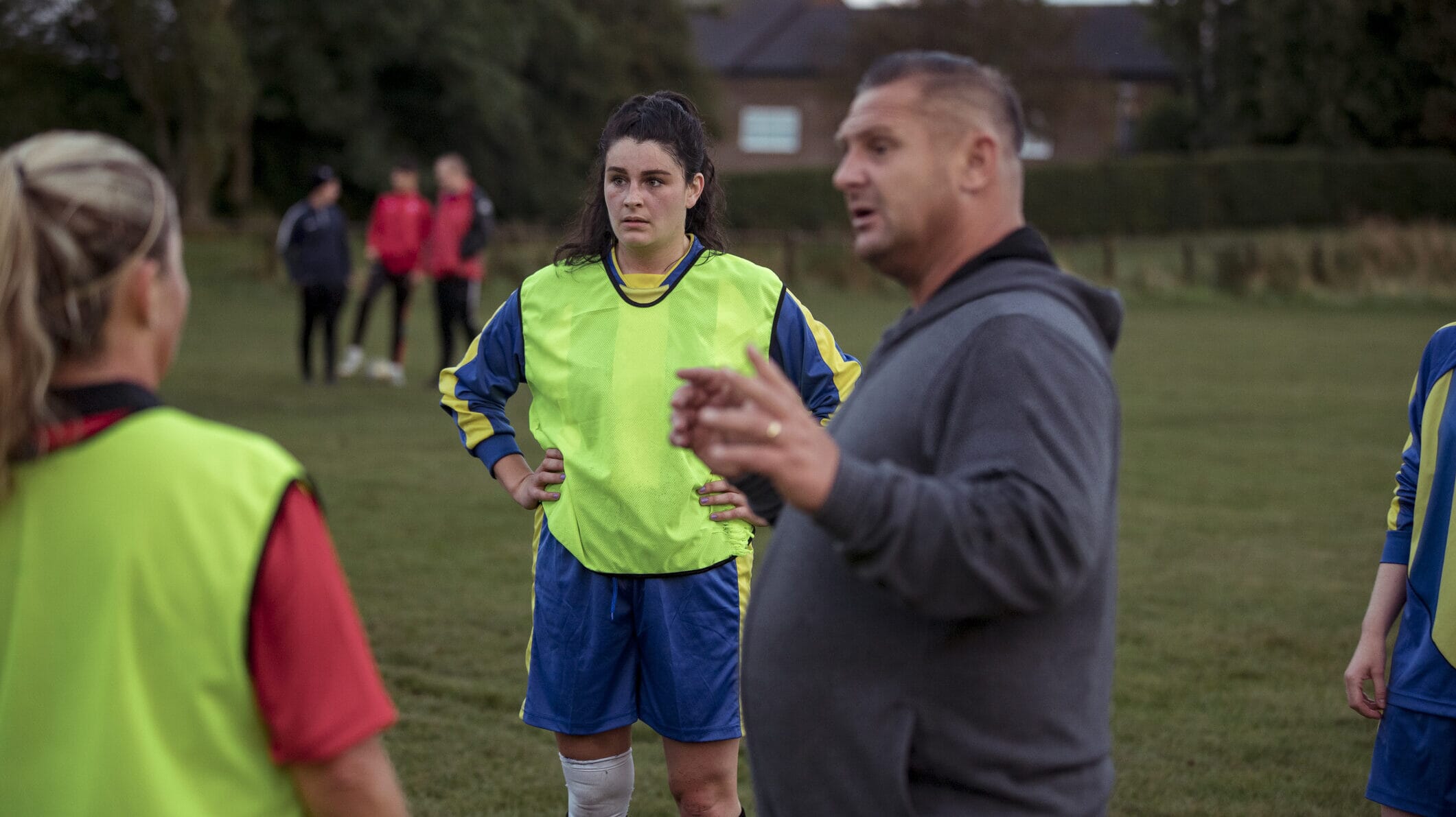 Coach leading a women's football training session, promoting safeguarding in sport.
