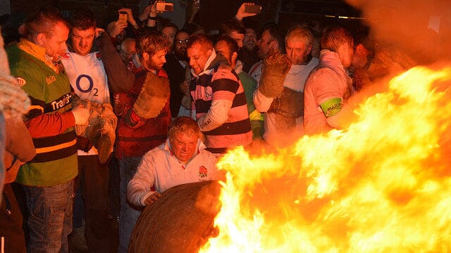 A participant carrying a flaming tar barrel through the streets of Ottery St Mary during this daring festive sporting tradition.
