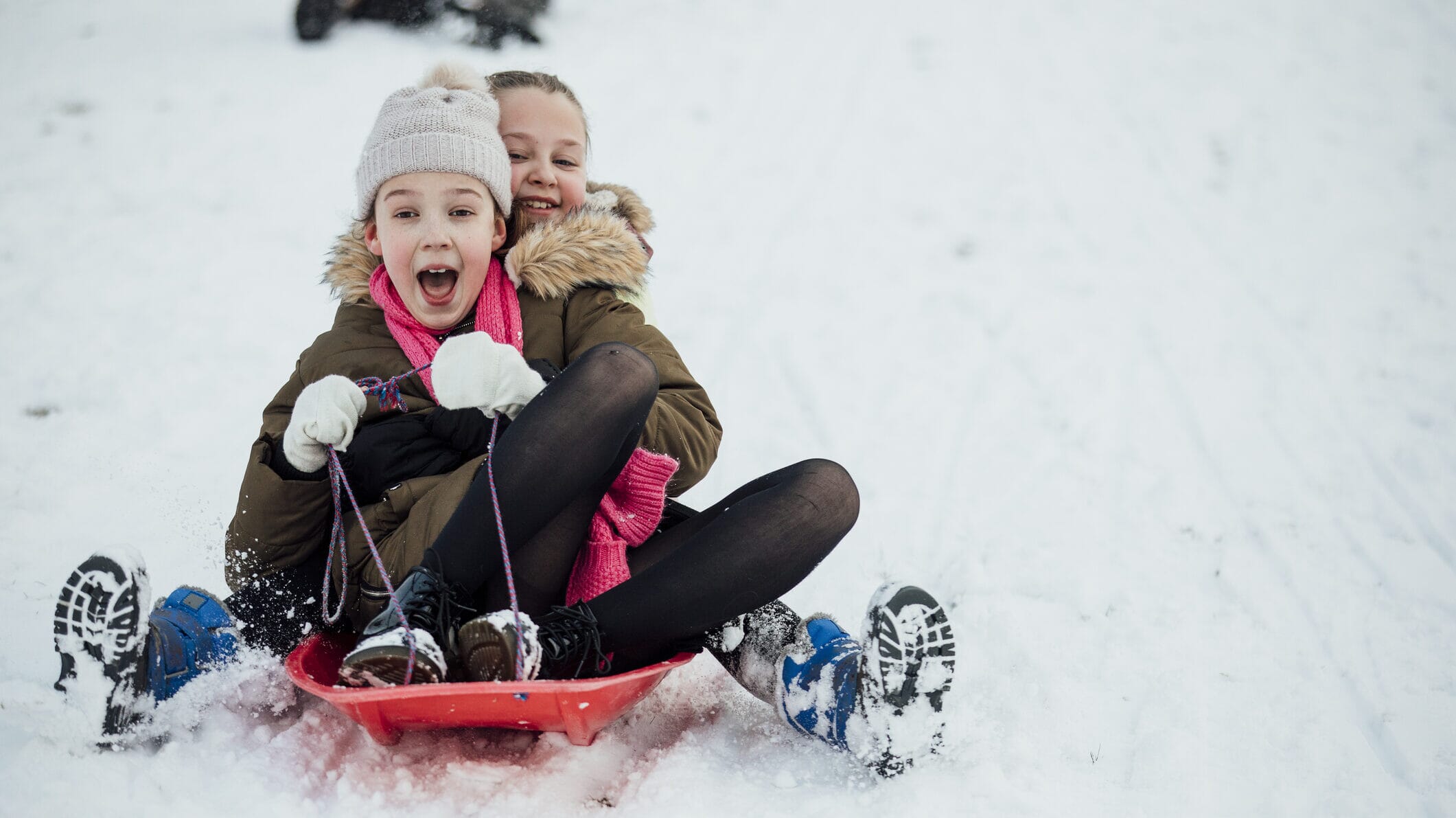 Fargerike sleder dekorert til jul konkurrerer ned en snødekt bakke.