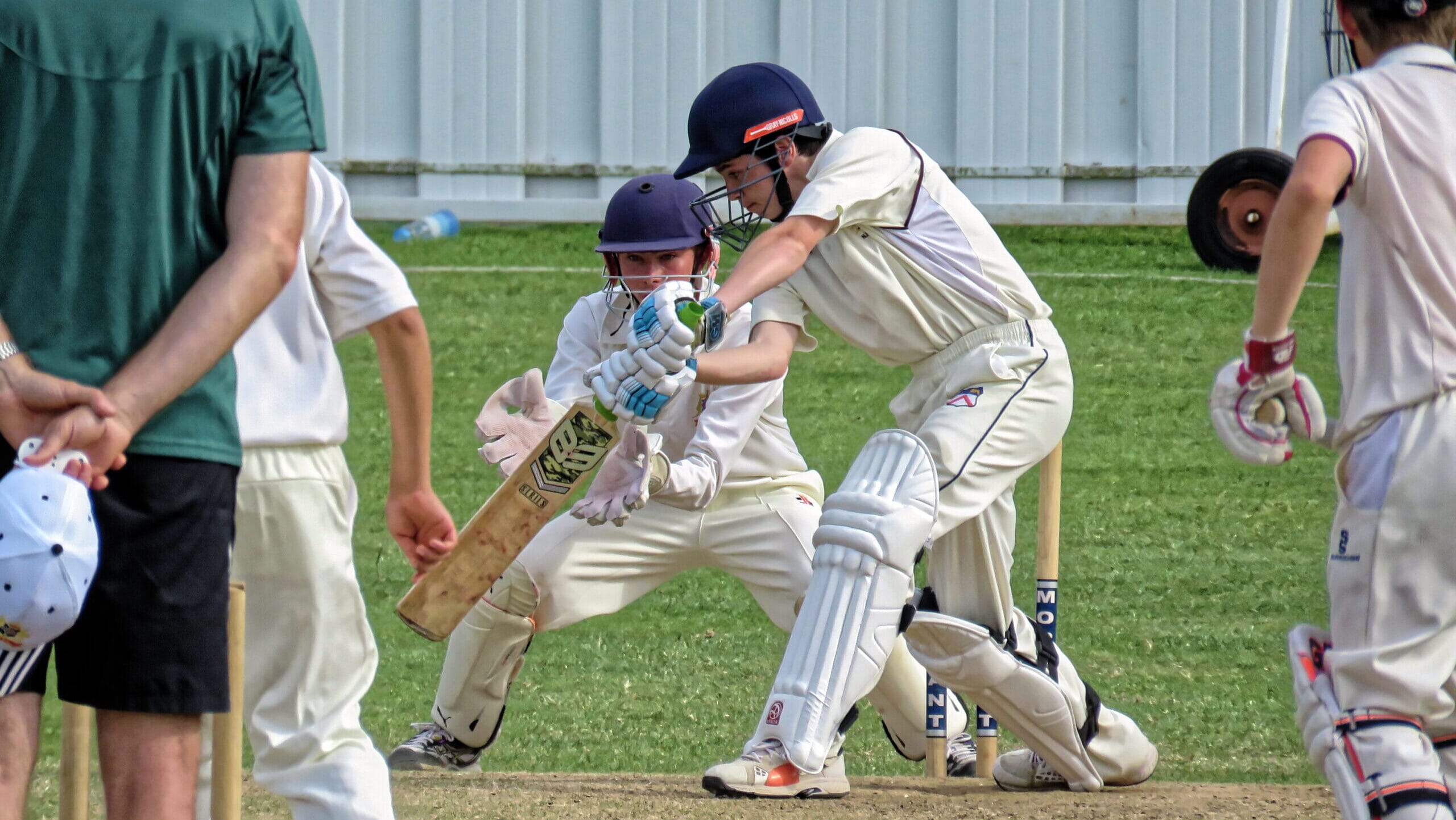 Cricketer batting on a sunny day with fielders and spectators, showcasing one of the biggest sports in the world.