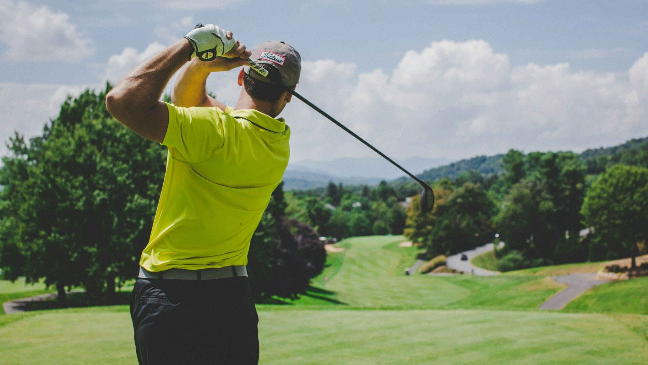 Golfer swinging a club on a picturesque course, highlighting golf as one of the biggest sports in the world.