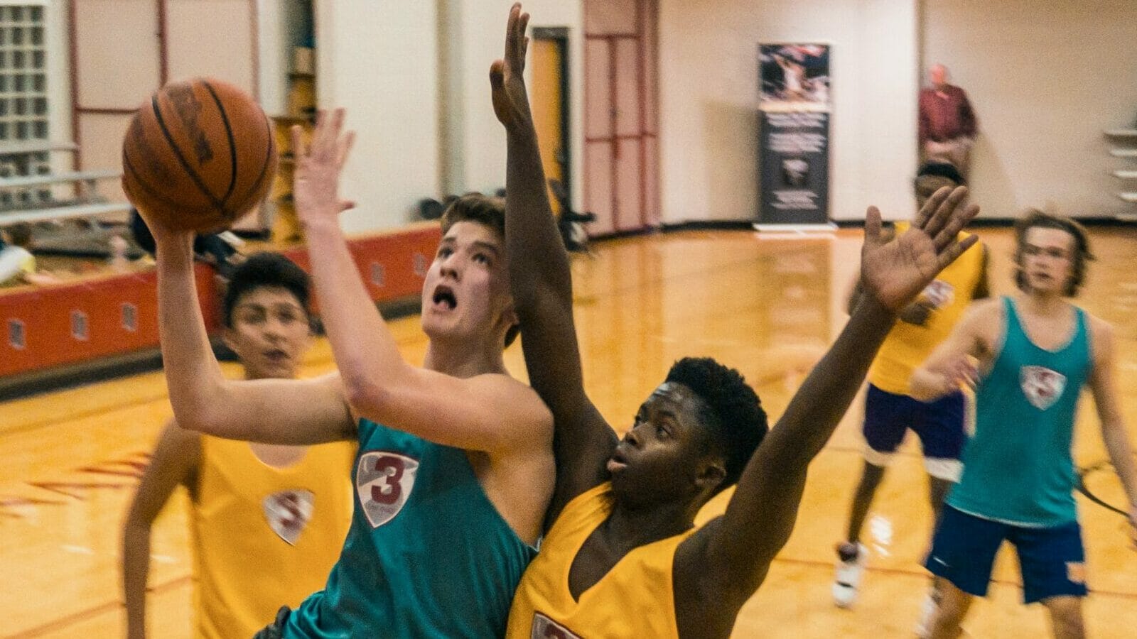 Basketball player executing a slam dunk in an indoor arena, highlighting its status among the biggest sports in the world.