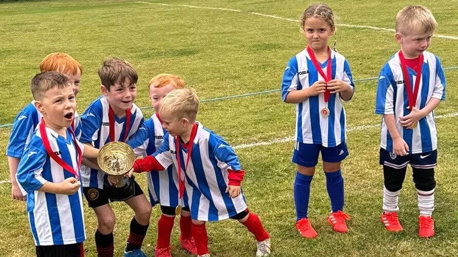 Junior Tykes FC members participating in Spond's Spot the Ball fundraising event, raising £1,800 to support grassroots football initiatives.