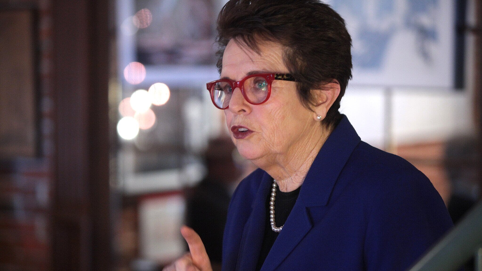 Billie Jean King returning a serve during the Battle of the Sexes, a true example of the greatest sporting figures in US history.