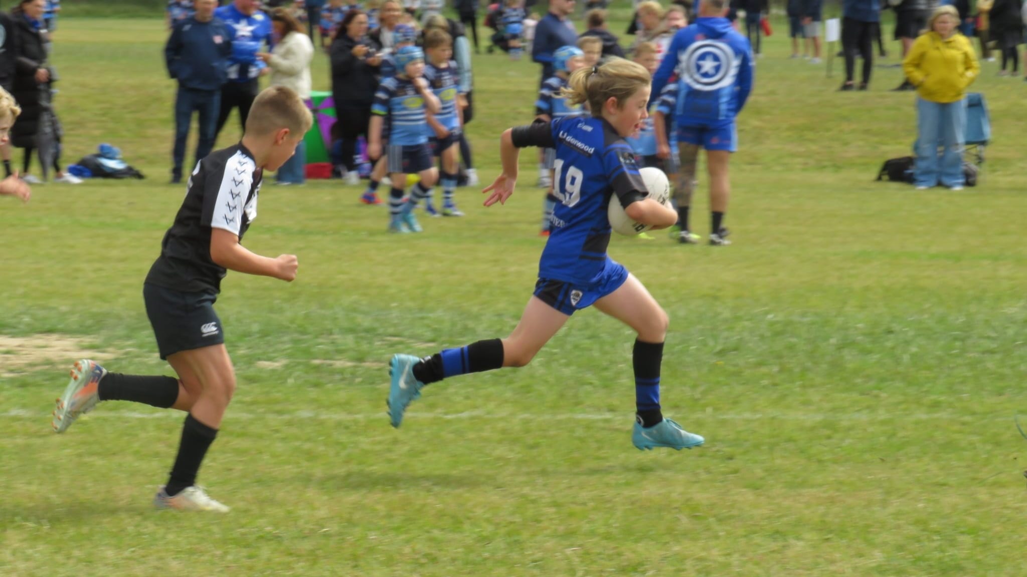 Parents and young players checking training schedules on the Spond rugby league app before a match
